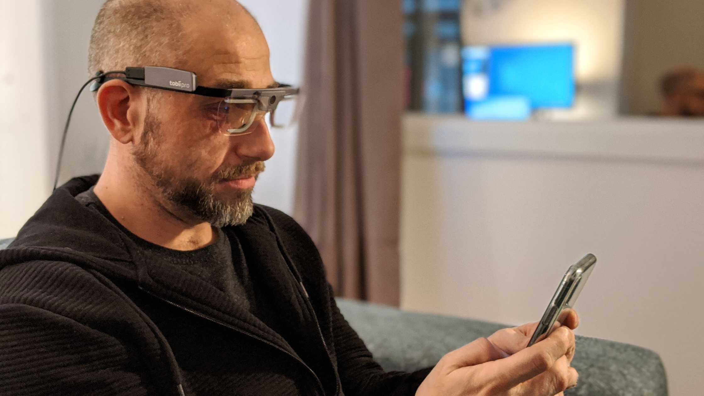 person using mobile with UX eye tracking glasses on