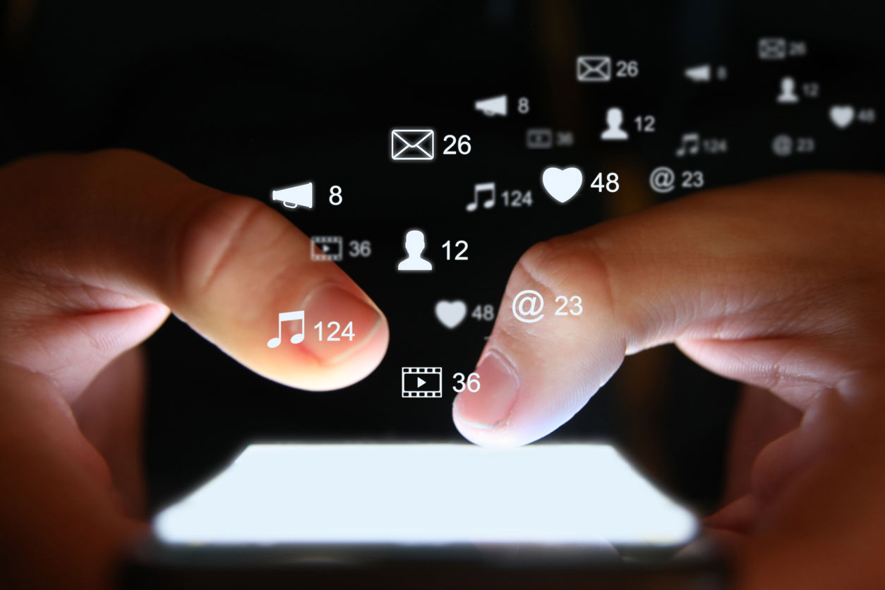 person on phone with social networking icons