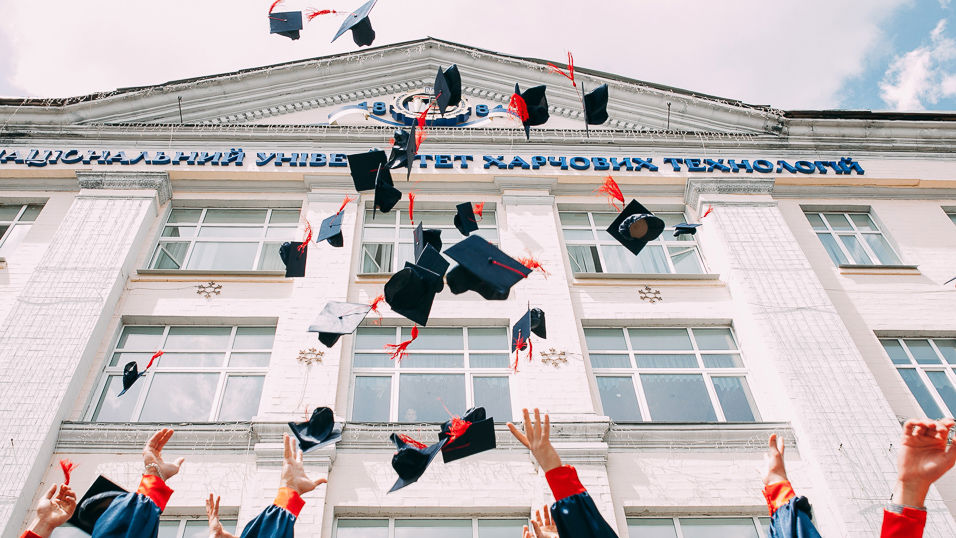 university graduates toss their mortar boards