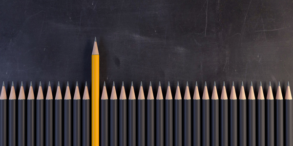 one orange coloured pencil standing out against grey pencils. istock 948942890