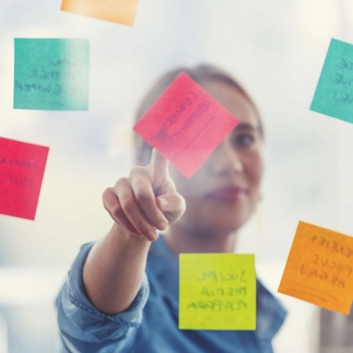 person brainstorming with sticky notes